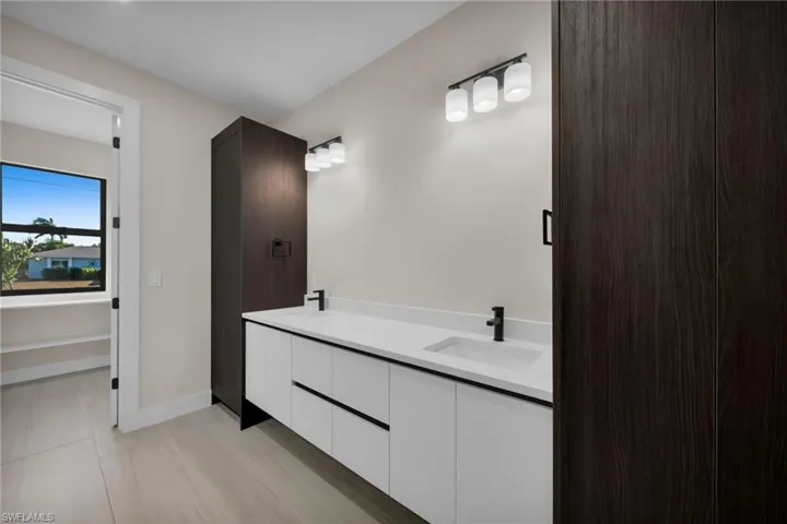 Full bath with double vanity and baseboards