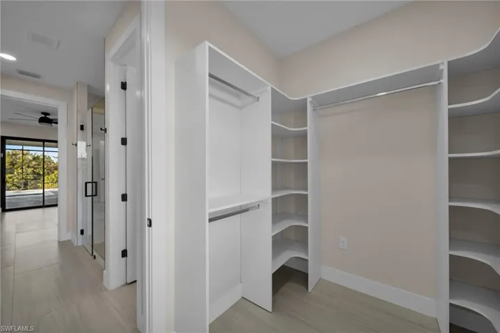 Walk in closet with ceiling fan and light wood-style flooring