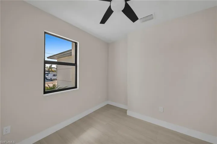 Unfurnished room with a ceiling fan and light wood-type flooring
