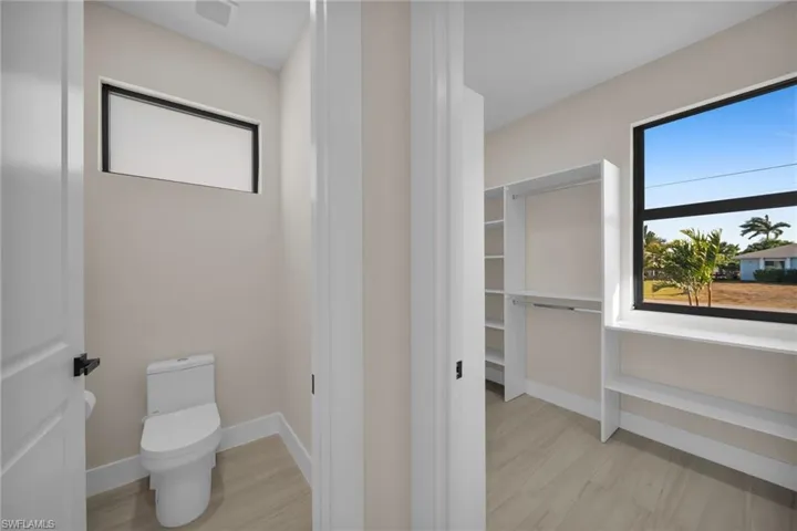 Bathroom with a walk in closet and light wood finished floors