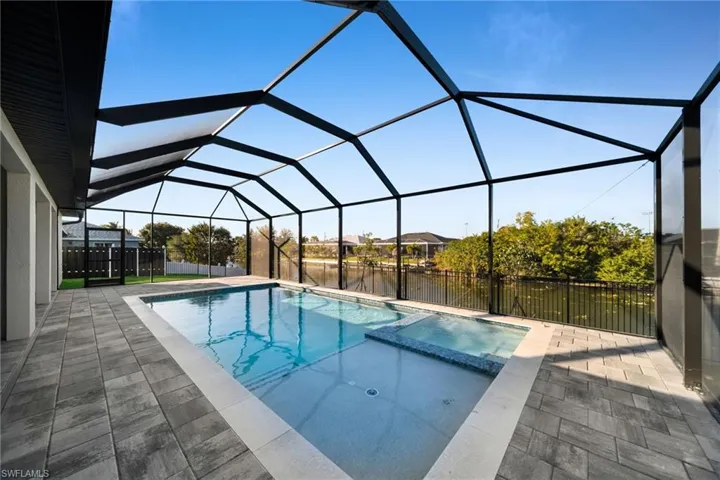 Relaxing pool / spa featuring a sunroom, a fenced backyard, and a lanai