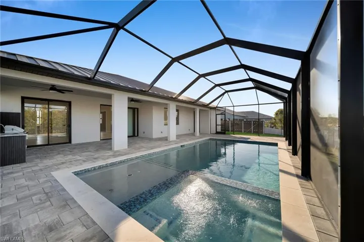 Integrated pool / spa with a sunroom, glass enclosure, and a patio area
