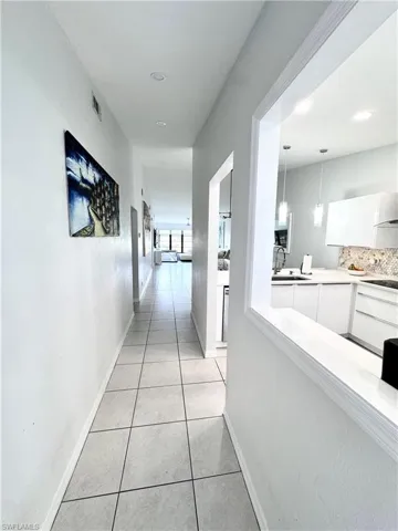 Hallway featuring light tile patterned floors and baseboards