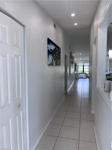 Hall with light tile patterned floors and recessed lighting