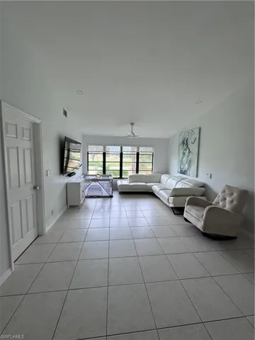Unfurnished living room with a ceiling fan and light tile patterned floors