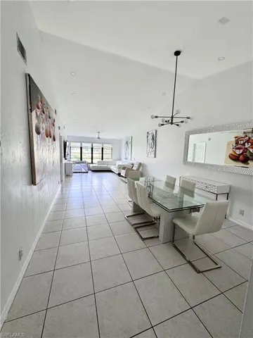 Dining space with light tile patterned floors and hanging lights