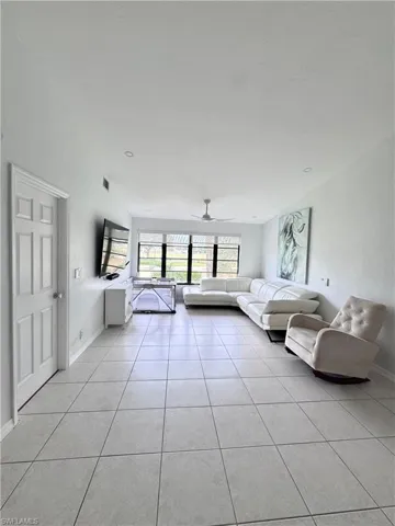 Unfurnished living room with a ceiling fan and light tile patterned floors