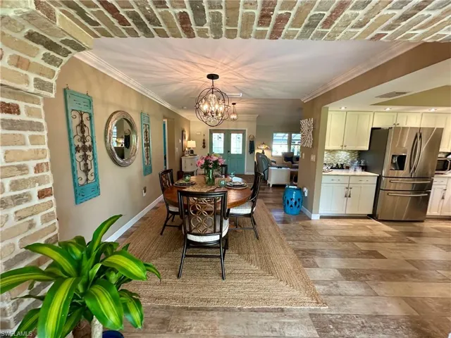 Dining room with crown molding, a chandelier, and light wood-type flooring