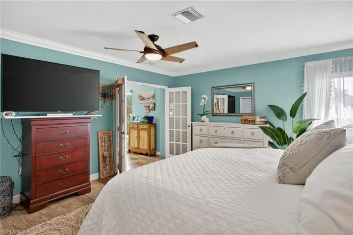 Bedroom featuring crown molding, ceiling fan, and wood finished floors