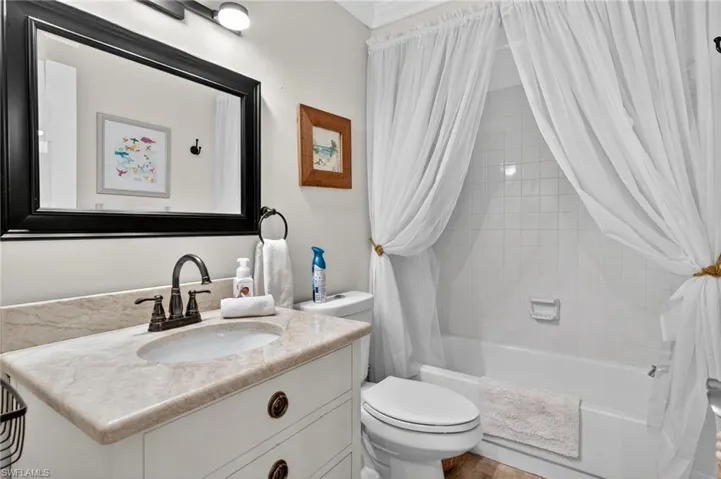 Full bathroom featuring shower / tub combo with curtain, vanity, and ornamental molding