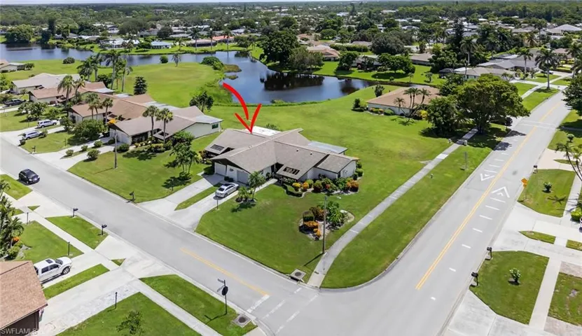 Aerial perspective of suburban area with a large body of water and a local golf course