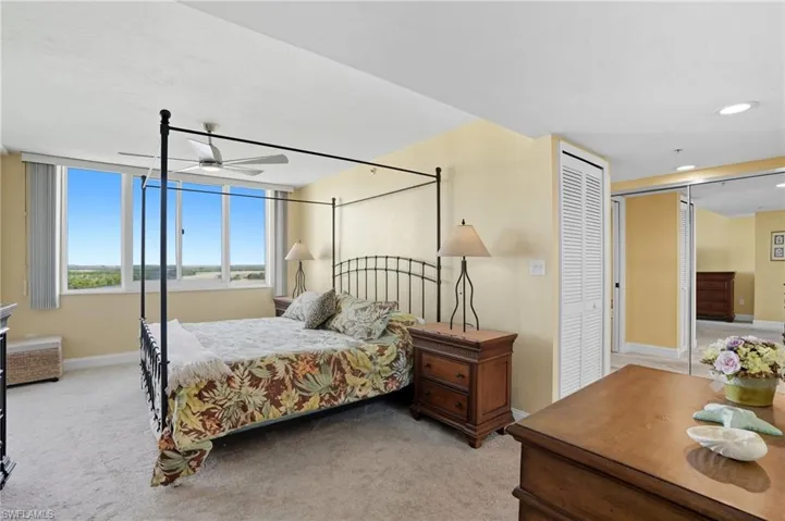 Bedroom with light colored carpet, a closet, and a ceiling fan - Virtually Edited Image