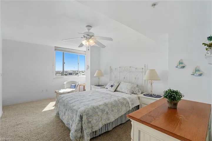 Carpeted bedroom with ceiling fan and baseboards - Virtually Edited Image