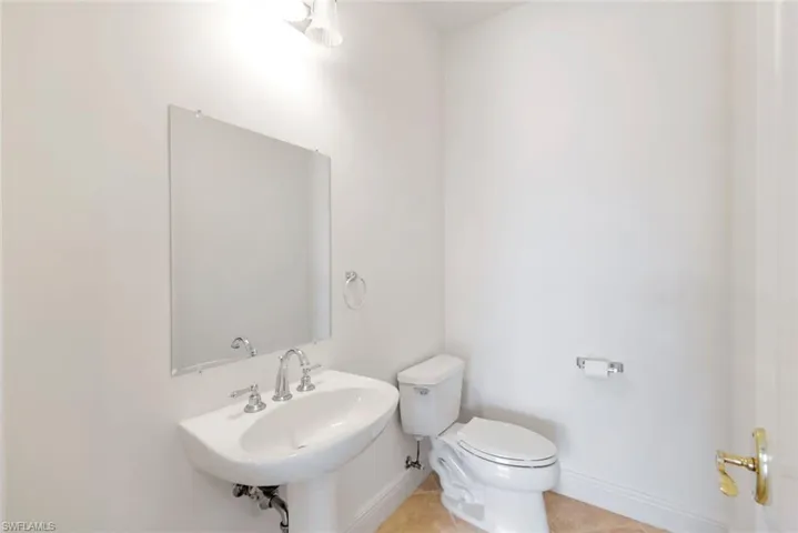 Bathroom with tile patterned flooring, toilet, and sink