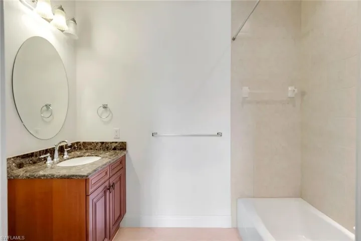 Bathroom with tile patterned flooring, vanity, and tiled shower / bath
