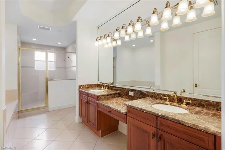 Bathroom featuring tile patterned floors, vanity, and an enclosed shower