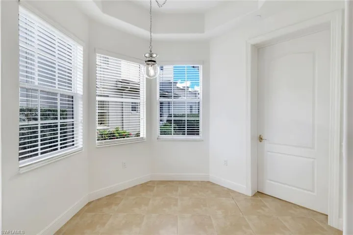 Unfurnished room featuring light tile patterned floors and a raised ceiling