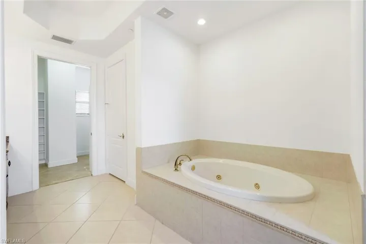 Bathroom with tile patterned flooring and a relaxing tiled tub