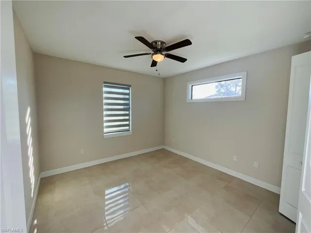 Unfurnished room with light tile patterned flooring and ceiling fan