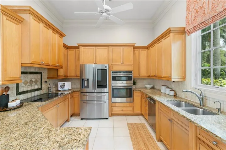 Kitchen with ceiling fan, tasteful backsplash, stainless steel appliances, light tile floors, and sink