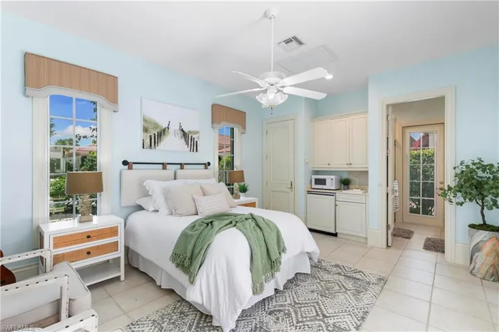Bedroom with ceiling fan and light tile floors
