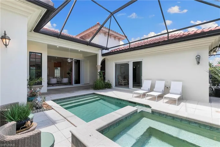 View of pool with ceiling fan, a lanai, an in ground hot tub, and a patio