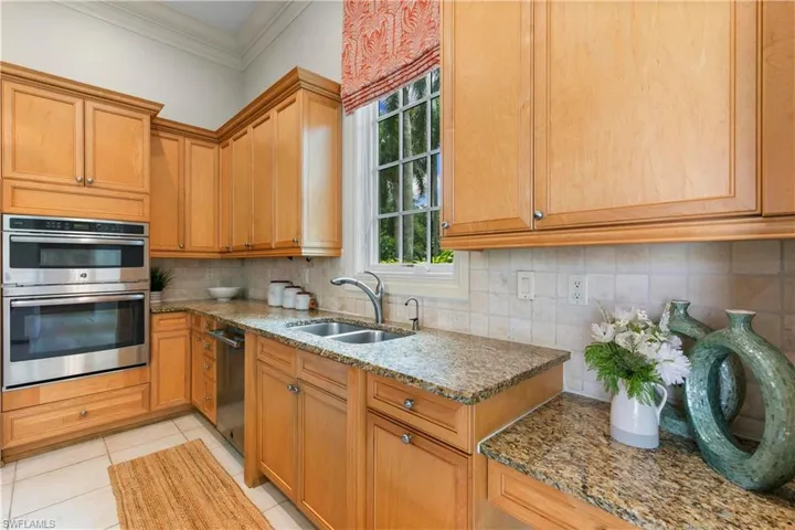 Kitchen with sink, tasteful backsplash, double oven, and light tile floors