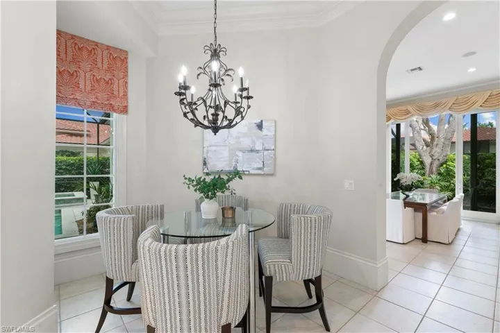 Dining space featuring a notable chandelier, ornamental molding, and light tile floors