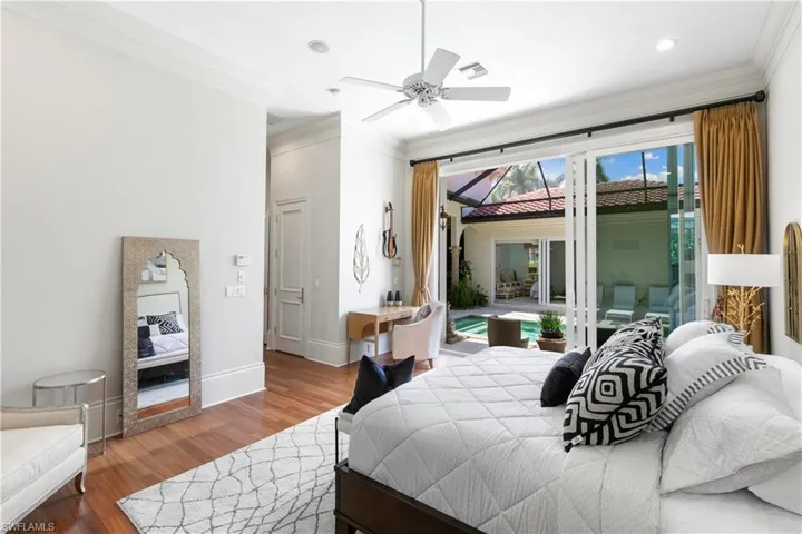 Bedroom featuring crown molding, wood-type flooring, and ceiling fan