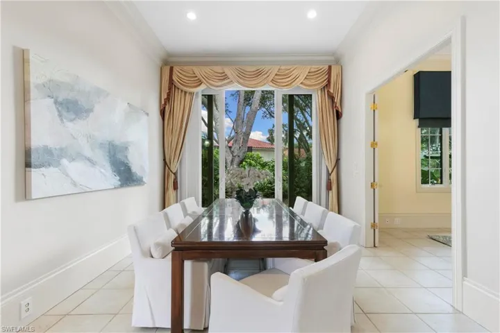 Dining space with crown molding, light tile flooring, and a wealth of natural light