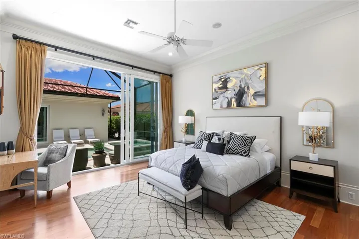 Bedroom with ceiling fan, multiple windows, hardwood / wood-style floors, and access to exterior