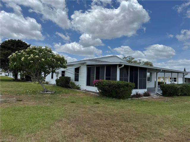 Manufactured / mobile home featuring a sunroom and a front lawn