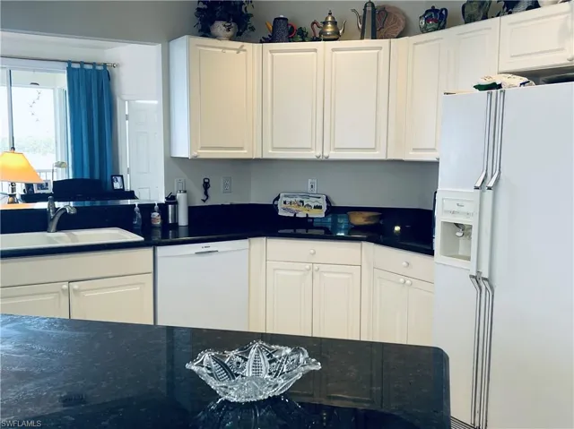 Kitchen with white cabinets and granite countertops.