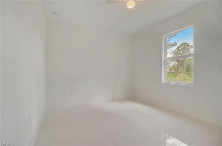 Tiled spare room with ceiling fan