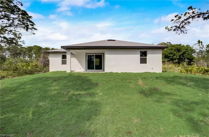 Back of property with a lawn
