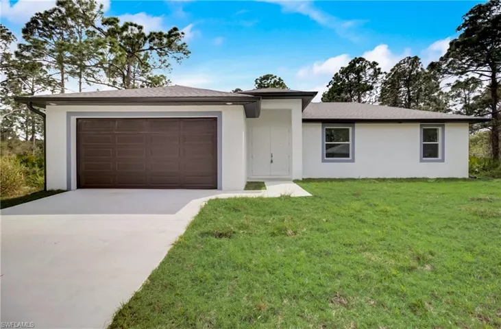 Ranch-style house with a garage and a front yard