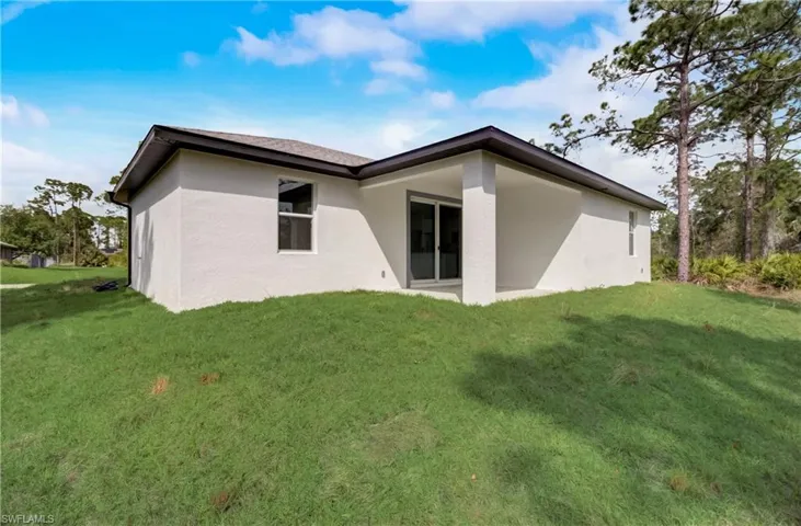 Back of house with a lawn