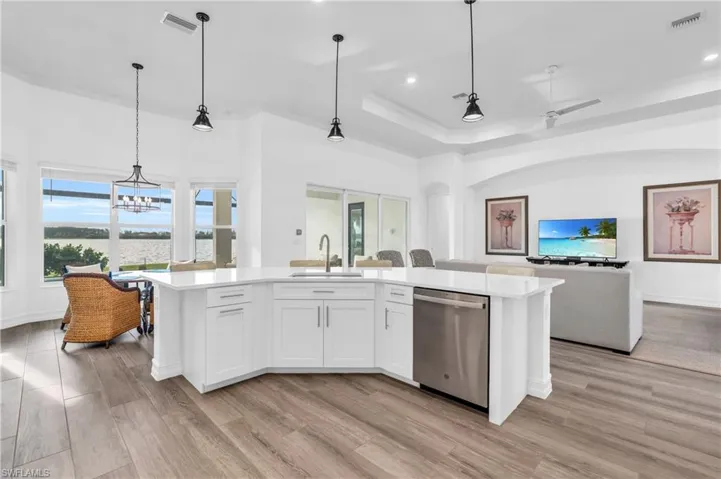 Kitchen with white cabinets, light hardwood / wood-style flooring, a center island with sink, stainless steel dishwasher, and sinkVirtually enhanced