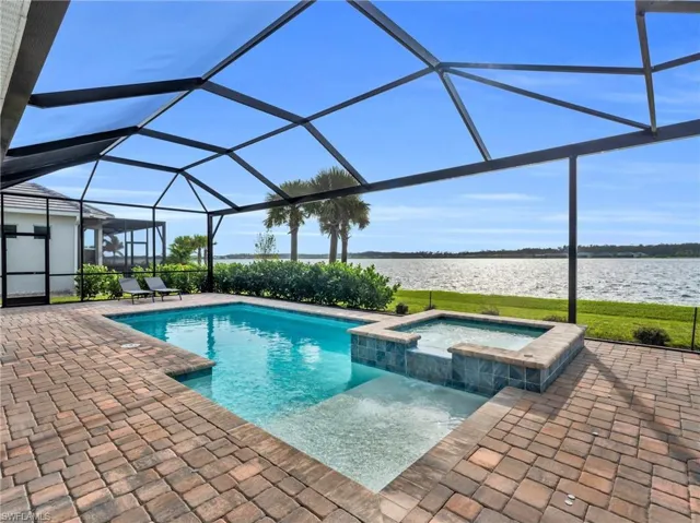 View of swimming pool featuring a lanai, a patio, an in ground hot tub, and a water viewVirtually enhanced