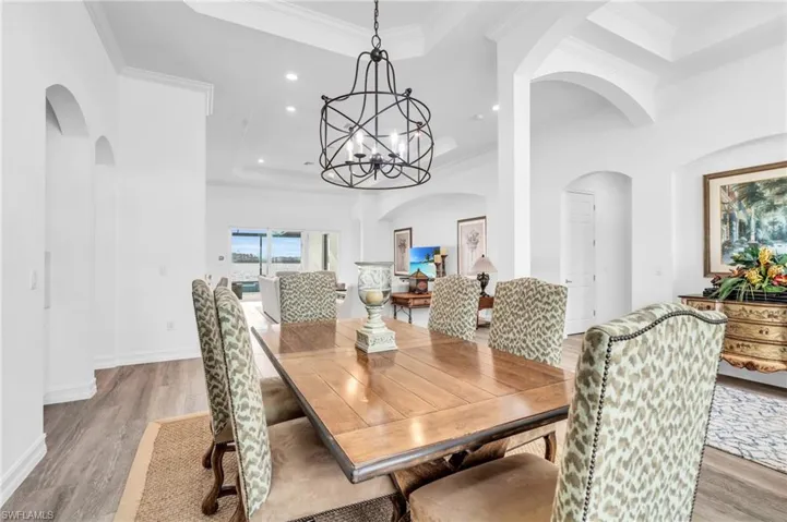 Dining space featuring light wood-type flooring, ornamental molding, and a chandelierVirtually enhanced