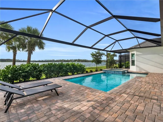 View of swimming pool featuring a lanai, a water view, an in ground hot tub, and a patio areaVirtually enhanced
