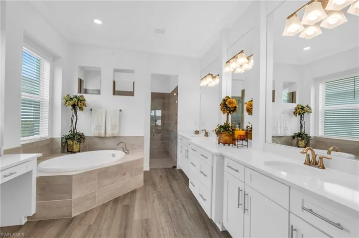 Bathroom with crown molding, wood-type flooring, vanity, and separate shower and tubVirtually enhanced