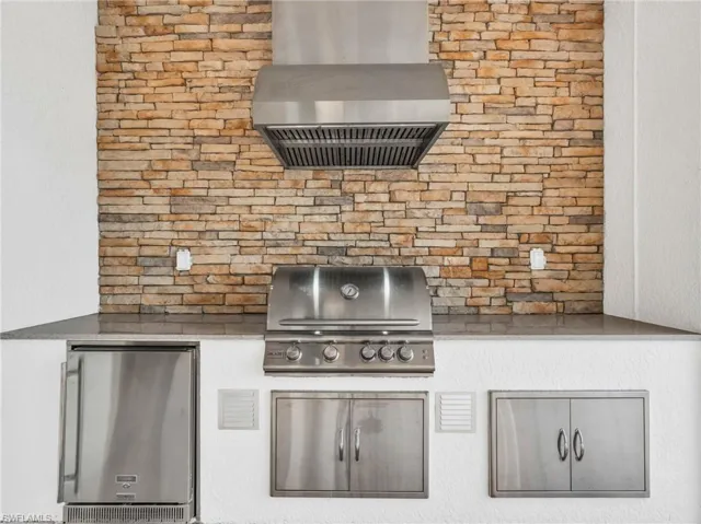 Kitchen with wall chimney range hood and stainless steel refrigeratorVirtually enhanced