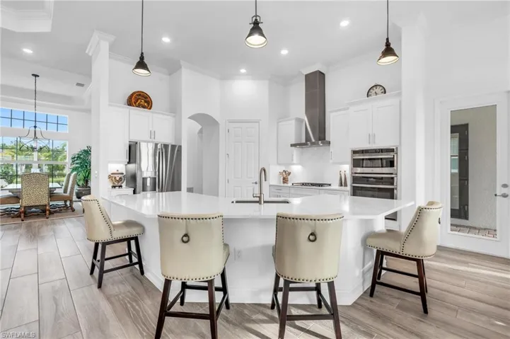 Kitchen with a large island, white cabinetry, appliances with stainless steel finishes, and sinkVirtually enhanced