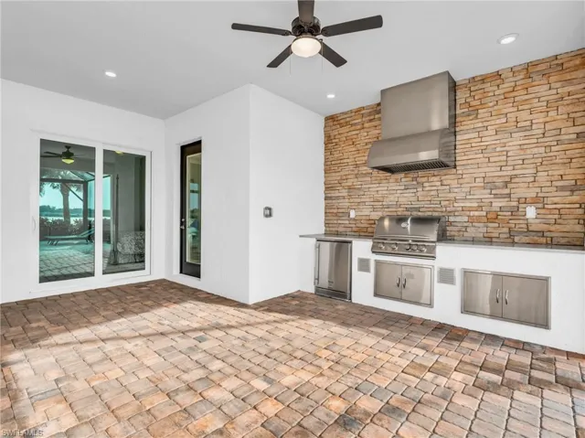 View of patio featuring an outdoor kitchen, ceiling fan, and a grillVirtually enhanced