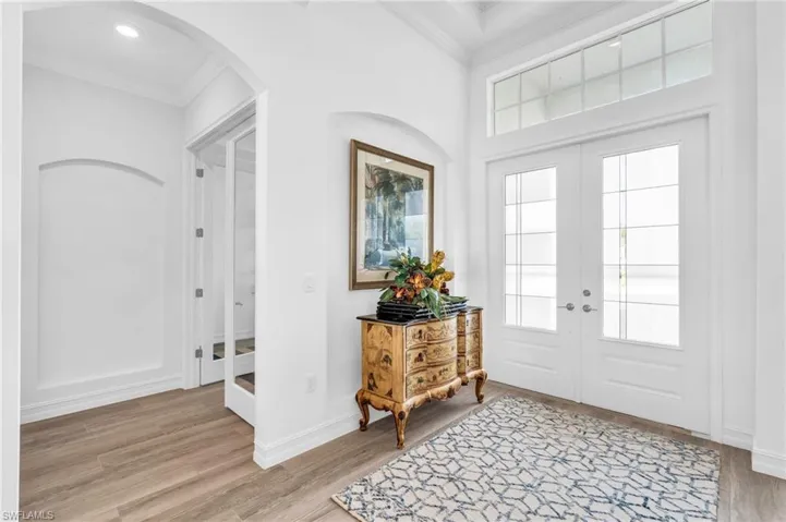 Entryway featuring light wood-style floors, french doors, and crown moldingVirtually enhanced