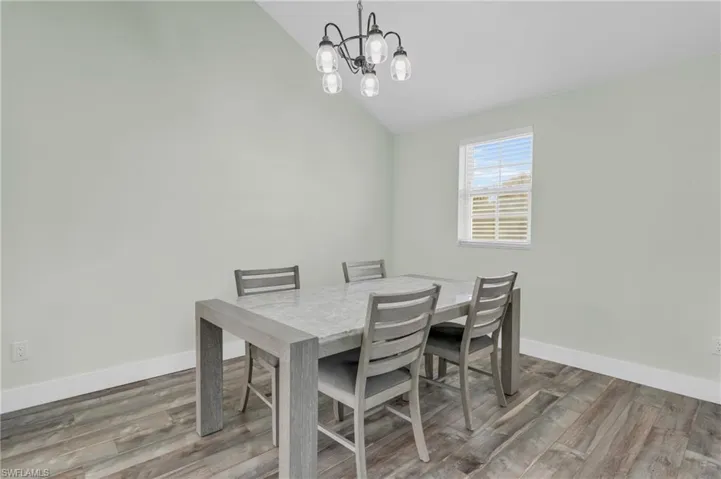 Dining space featuring lofted ceiling, a chandelier, and hardwood / wood-style flooring