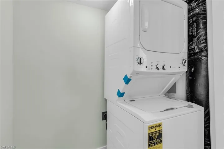 Washroom featuring stacked washer / drying machine