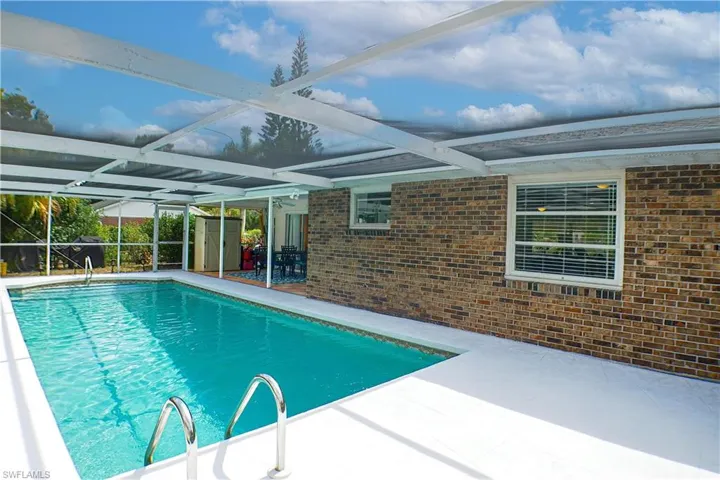 View of swimming pool with a patio and a lanai