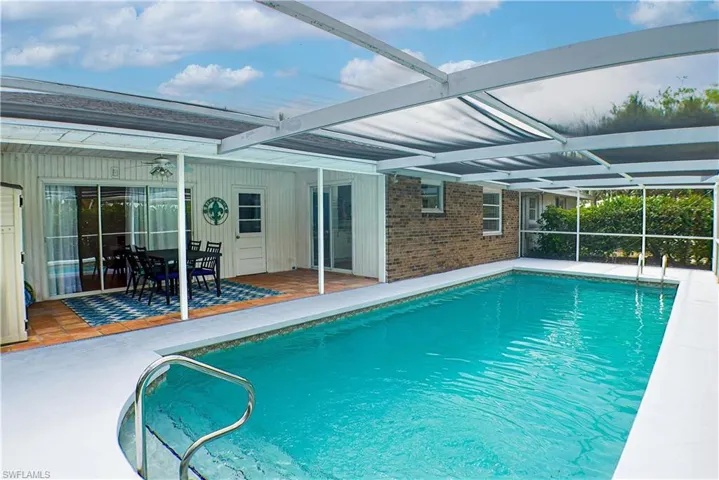 View of swimming pool featuring a patio and a screened-in lanai